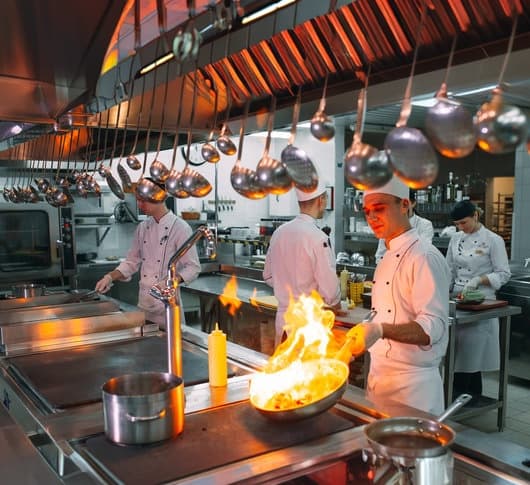 A chef tossing a flaming wok in the Kaustubh kitchen.